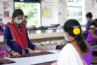 MASKED GARMENT EMPLOYEES IN INDIA: Several factories, including Pratibha Syntex in India, quickly converted to manufacturing PPE, including masks, at the onset of the pandemic.