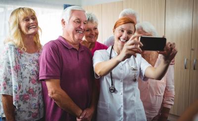 A nurse taking selfie with seniors