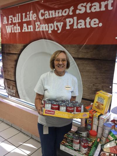 An employee at Smithfield Foods’ Middlesboro, KY facility stands with the facility’s donation for Hunger Action Month, a time when people across the country stand together with Feeding America and its nationwide network of food banks to fight hunger.