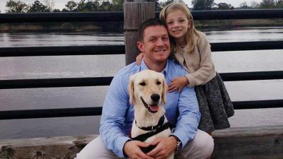 U.S. war veteran, SSG, Jeremy Fouts shares a special bond with his assistance dog EMMA*, who helps mitigate his PTS symptoms. The paws4vets program matches assistance dogs with wounded veterans, active-duty service members and their families. Pictured here are Fout’s, his daughter and EMMA. *paws4people foundation refers to EMMA and all of their assistance dogs using capital letters.