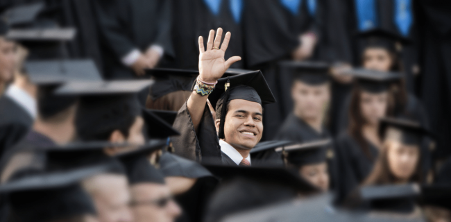 man wearing cap and gown waving