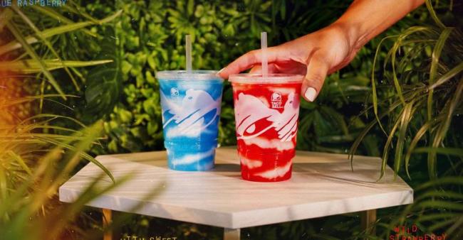 One blue and one red island berry freeze, with a hand reaching for the red one.