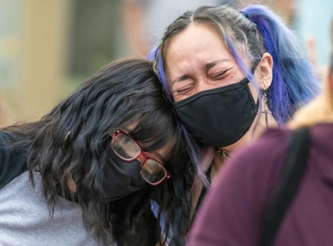 Protesters embrace at a demonstration in September 2020 outside a motel in San Clemente, CA, where a homeless Black man was shot and killed. MEDIANEWS GROUP VIA GETTY IMAGES
