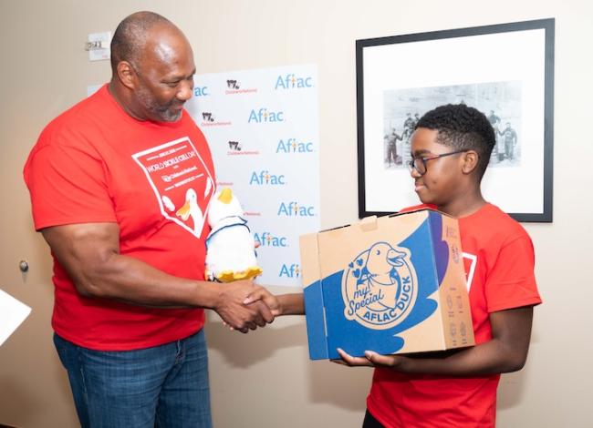 Aflac Senior Vice President of Federal Relations Brad Knox delivers a My Special Aflac Duck to 10-year-old sickle cell patient Kendric Comer at Nationals Park in Washington, D.C. Aflac treated sickle cell patients from Children's National Hospital to a day at the ballpark to commemorate World Sickle Cell Day on June 19.    