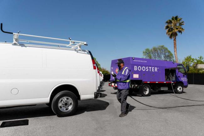 Booster tanker fueling a white van