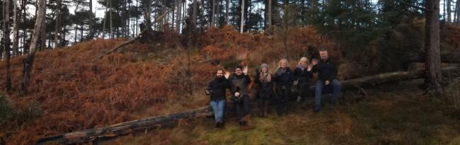 a group of people in the woods waving at the camera
