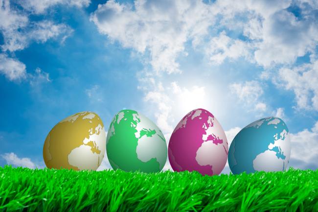 eggs with globe pattern on grass with blue sky background