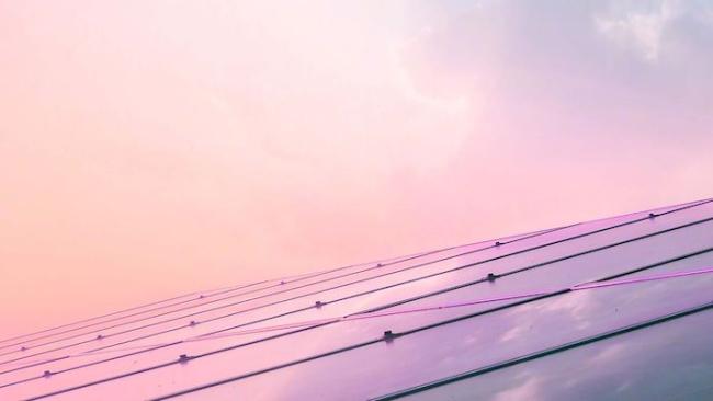Solar panel array against a purple sky.