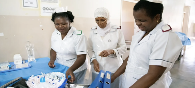 Nurses working in a hospital room.
