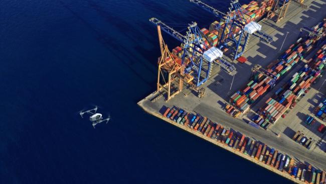 a drone flies above a shipping port