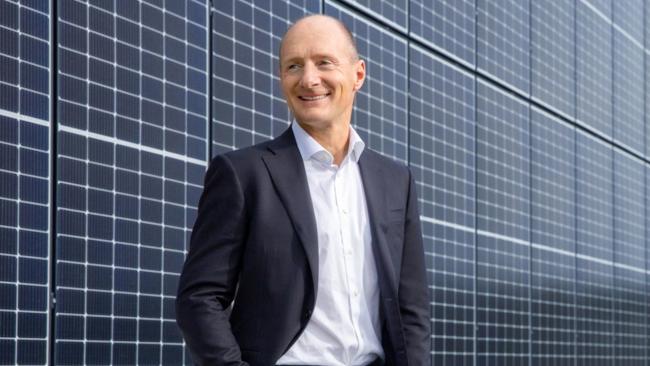 Magnus Groth standing in front of solar panels