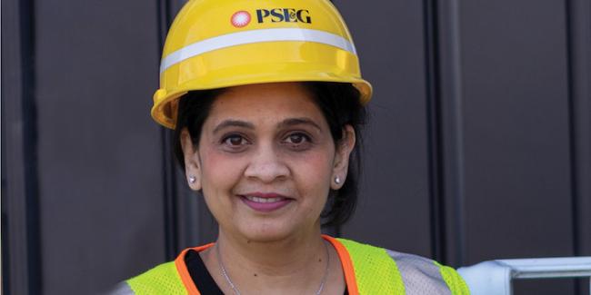Female PSEG employee wearing a hardhat and safety vest.