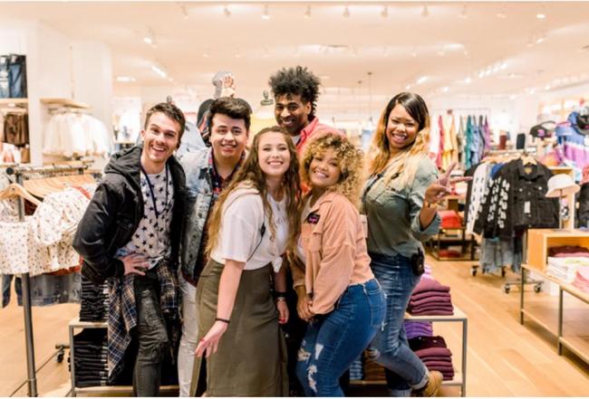 6 people standing together in a clothing store