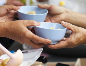 Hands sharing bowls of food