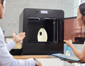 2 people using a 3D printer