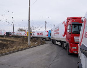 convoy of semi trucks all with red crescent logo on the side