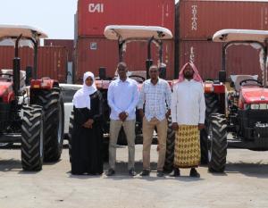 Gaalooge team members standing in front of several tractors