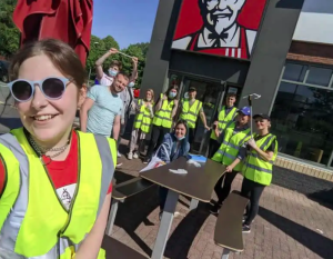 KFC employees in hi-vis vests cleaning up litter