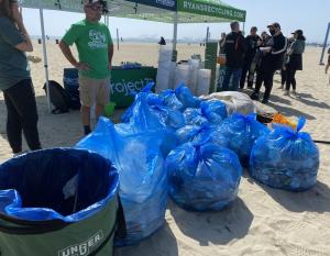 Working together LA Kings and Anaheim Ducks team members collected over 490 pounds of trash in partnership with Ryan's Recycling Company people picking up trash along a beach