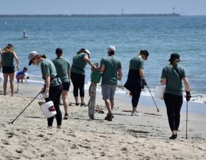 In celebration of Earth Month, over 125 team members from the LA Kings and Anaheim Ducks participated in a beach cleanup in Long Beach, CA people picking up trash along a beach