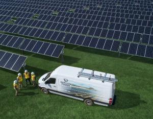 workers near a utility van and solar panels