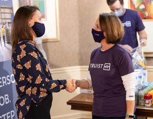 Amelia Nickerson, CEO at First Step Staffing shaking hands with a volunteer