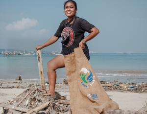 Woman with a bag of trash cleaned from the beach