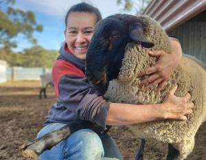 Rachel Chirgwin, hugging a sheep