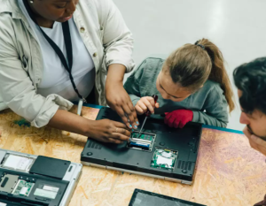 Students taking apart a laptop computer