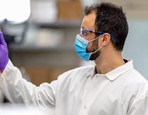 Scientist looking at a vial