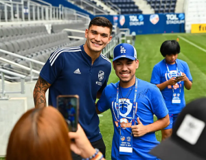 Student posing with an MLS player