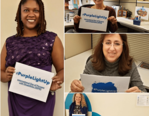 Employees holding #PurpleLightUp signs