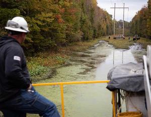 Duke employee on a boat in the swamp