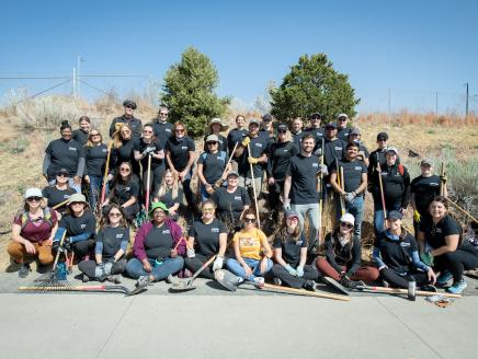 Arrow employees pose for a group photo while planting trees on Earth Day 