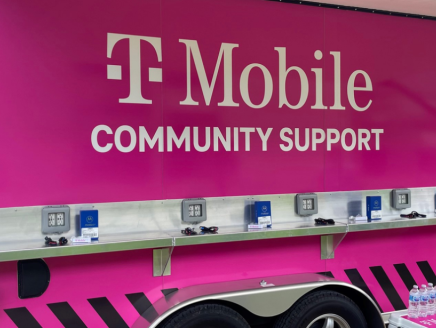 TMobile logo on the side of a pink vehicle "community support" equipped with charging ports