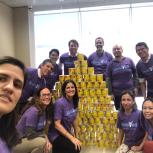 Group wearing "Involved" T-shirt and posing by a pyramid of cans