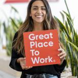 person holding a sign saying "Great Place to Work"