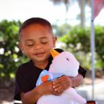 Gabe giving a big hug to his stuffed Aflac duck