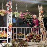 Rodrique's Mom on her front porch surrounded by hanging flower pots and baskets on the floor