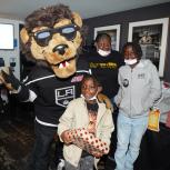 LA Kings mascot Bailey poses with families during the LA Kings Adopt-A-Family event at Crypto.com Arena (formerly STAPLES Center).