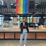 Lutz in a cafeteria, under a rainbow pride flag
