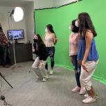 students standing in front of a green screen