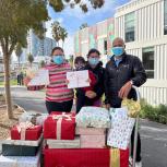An AEG employee delivers a wagon full of presents to a family in need. 