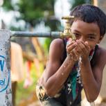 Child drinking water from a spout