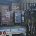 a trailer full of pallets marked with FedEx Cares, humanitarian relief. a person looking in.
