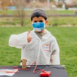 Boy giving thumbs up in front of science project