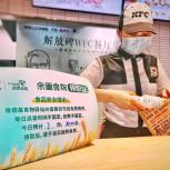 KFC China worker bags food next to a sign for the food bank