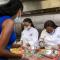 Culinary Director Quin Kelly (left) provides tips on chopping vegetables while prepping meals with students.