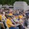 A seated crowd, many wearing the same yellow shirt designating them as a participant in the honor flight program