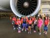 Class of girls in front of jet engine